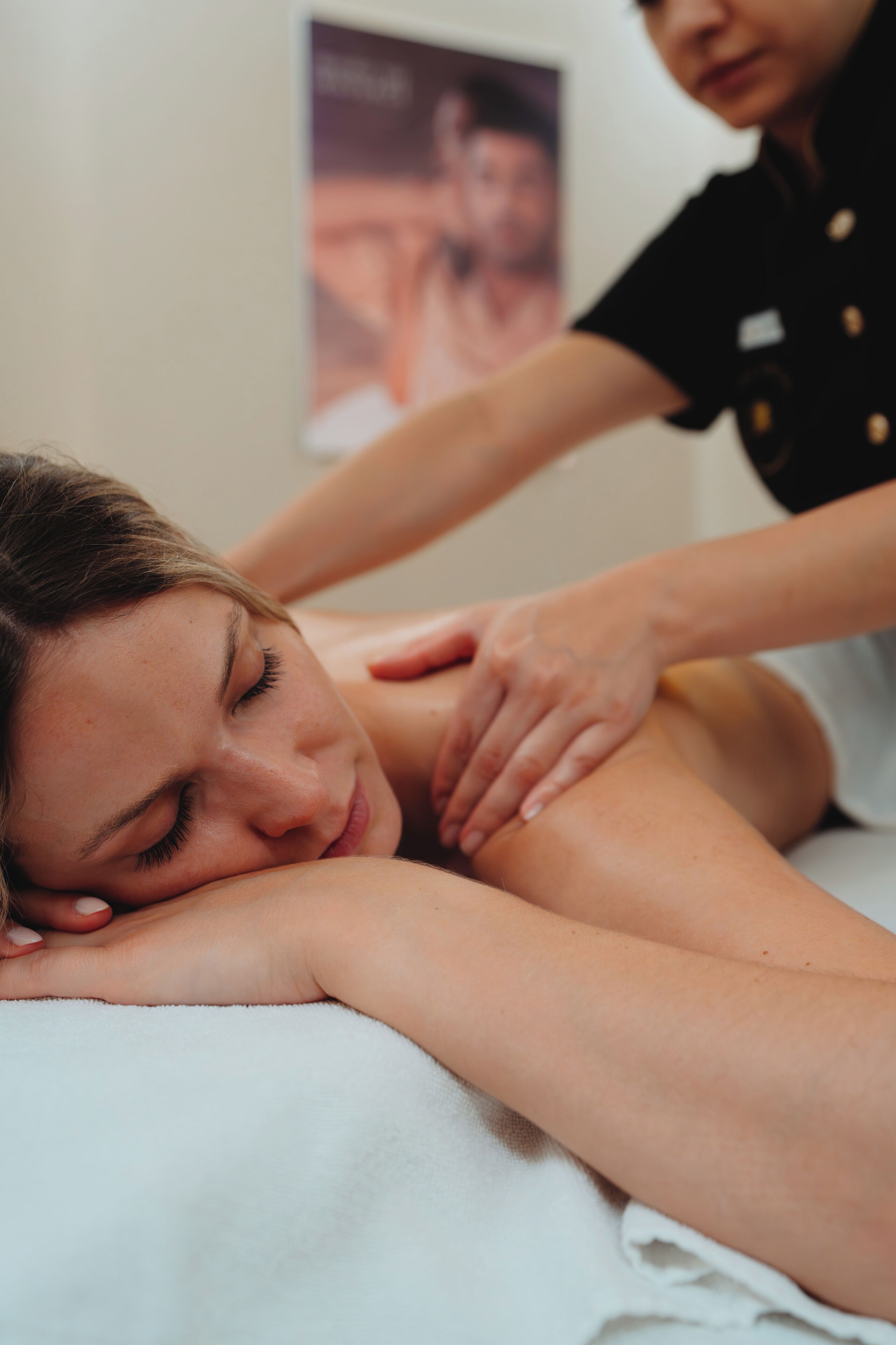 A person receiving a massage on a massage table.