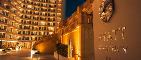 Fachada imponente de un hotel, con un gran arco de entrada y un cartel que dice 'HYATT REGENCY MALTA'.