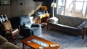 Ein Wohnzimmer mit einer Couch, Sesseln, einem Couchtisch und einem Fernseher.
