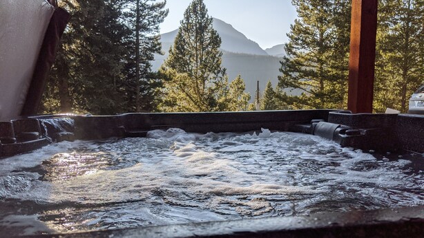 A hot tub with a view of a mountain and trees.