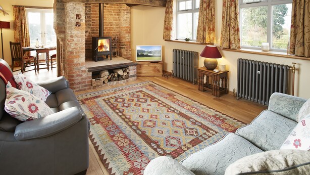 Una sala de estar acogedora con chimenea, sofás y un tapete grande.