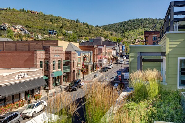 A street view of a town with various buildings, including a restaurant and a store with a sign that reads "Egyptian."