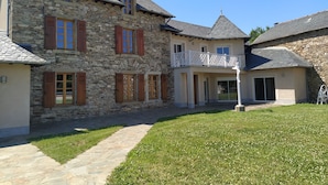 Un bâtiment en pierre doté de nombreuses fenêtres et d’un balcon.