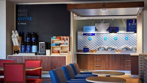 A modern cafe with a coffee station, seating area, and a counter with food options. - Holiday Inn Express & Suites Bardstown by IHG (Bardstown)