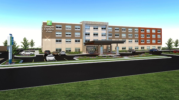 Un bâtiment Holiday Inn Express & Suites doté d’un parking, d’une entrée couverte et d’un espace paysager agrémenté de fleurs.