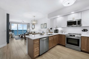 Una cocina moderna con gabinetes blancos, electrodomésticos de acero inoxidable y una isla grande con lavavajillas.