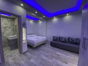 Une chambre à coucher moderne avec un lit, un canapé et une salle de bain.