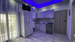 A modern kitchen with wooden cabinets, a built-in microwave, and a flat-screen TV mounted on the wall.