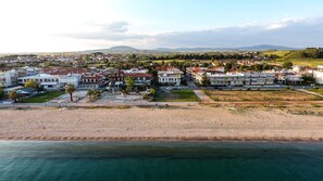 Vue aérienne d’une ville côtière avec des immeubles résidentiels, une plage de sable et une vue dégagée sur la mer.