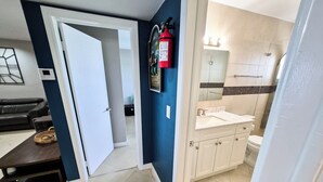 A modern bathroom with a white sink, toilet, and a shower area.