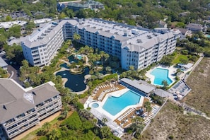 Un hôtel composé de plusieurs bâtiments, doté d’une grande piscine centrale et de plusieurs piscines plus petites.