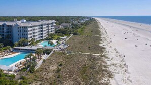A beachfront hotel with a swimming pool, beach access, and a view of the ocean.
