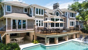 Uma casa grande com piscina, deck e área de estar externa.
