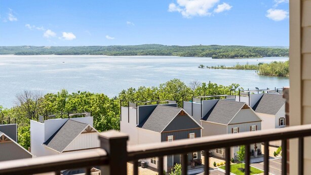 A residential area with houses overlooking a large body of water and a distant hill. - Branson Getaway • Sunroom + Balcony + Stunning Table Rock Lake View (Branson)