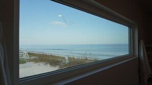 Quarto com uma grande janela com vista para a praia.