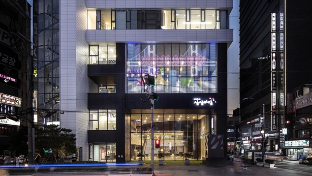 Un edifici modern amb cartelleria il·luminada i una gran finestra de vitrina.