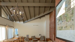 A spacious room with a high ceiling, wooden furniture, and a large map on the wall.