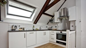 A modern kitchen with white cabinets, a built-in oven, and a skylight. - Free Parking - Free Wi-Fi - 2km From The Beach (Strete)