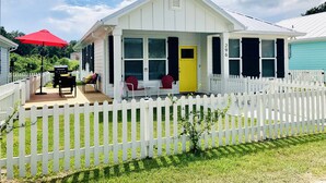 A white house with a porch, a yellow door, and a white picket fence. - Yellow Door Cottage In The Heart of Bay St. Louis (Bay St. Louis)