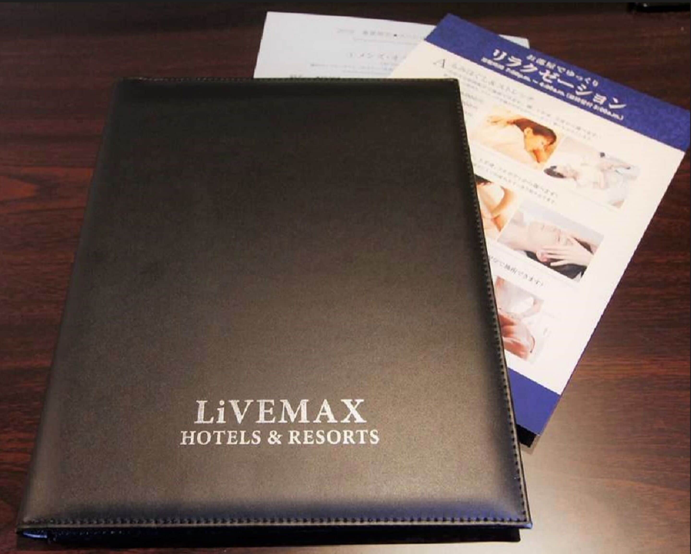 A black folder labeled "Livemax Hotels & Resorts" with brochures on top.
