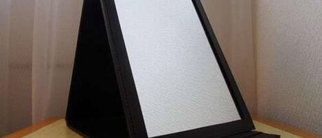 A black standee with a white background, placed on a wooden surface against a plain wall.