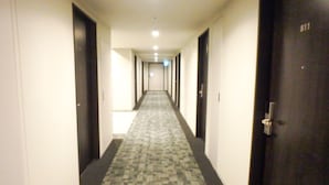 Un pasillo de hotel con pisos alfombrados, puertas a ambos lados y la puerta número 811 a la derecha.