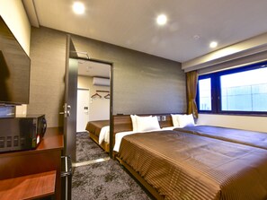 Ein Hotelzimmer mit Bett, Schreibtisch, Fernseher und einem Fenster mit Vorhängen.