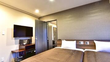 A hotel room with two beds, a flat-screen TV, a desk, and a mirror.