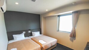 A hotel room with two beds, a window with curtains, a dark headboard, and a small desk with a computer. - Hotel Livemax Kokura-ekimae (Kitakyushu)