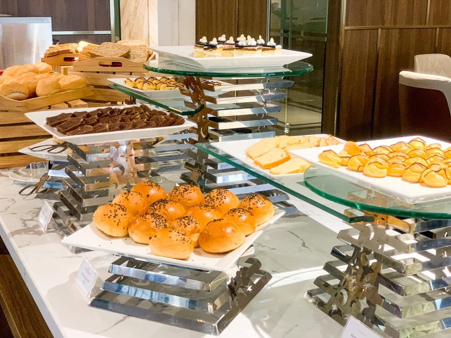 A buffet with various baked goods and desserts.