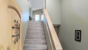 Una escalera de madera con barandilla que conduce a un piso superior.