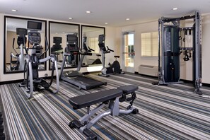A gym with treadmills, elliptical machines, a bench, and a squat rack. - Candlewood Suites Lodi (Lodi)