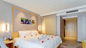 A hotel room with a bed, bedside table, and a wall-mounted TV. - Lavande Hotels (Xi'an Xibu Avenue Yangguangcheng) (Xi'an)