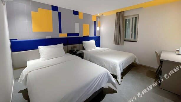 Une chambre d’hôtel avec deux lits, un bureau et une fenêtre.