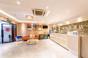 A hotel lobby with a reception desk, seating area, and a large window. - Wei'erdun Hotel (Shenzhen Bao'an Lingzhi Metro Station) (Shenzhen)