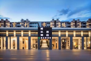 L’entrée d’un hôtel, avec une enseigne bien visible, plusieurs points d’accès et une façade bien éclairée.