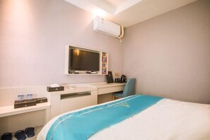 A hotel room with a bed, a desk, a chair, a TV, and an air conditioning unit. - Wei'erdun Hotel (Shenzhen Bao'an Lingzhi Metro Station) (Shenzhen)