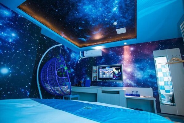 A bedroom with a galaxy-themed ceiling, a bed, a desk with a computer, and a hanging chair. - Wei'erdun Hotel (Shenzhen Bao'an Lingzhi Metro Station) (Shenzhen)