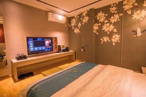 A hotel room with a bed, a TV on a stand, a wall with floral decorations, and a door with a bird design. - Wei'erdun Hotel (Shenzhen Bao'an Lingzhi Metro Station) (Shenzhen)