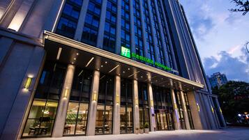 A modern hotel building with a prominent entrance, large windows, and a sign indicating it is a Holiday Inn Express.