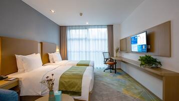 A hotel room with two beds, a desk, a chair, a TV, and a plant.