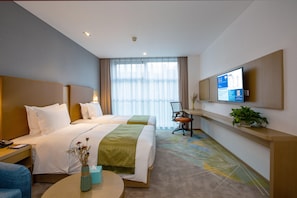 Une chambre d’hôtel avec deux lits, un bureau, une chaise, une télévision et une plante.