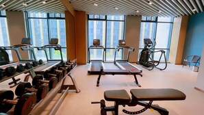 Un gimnasio con cintas de correr, elípticas y bancos de pesas.