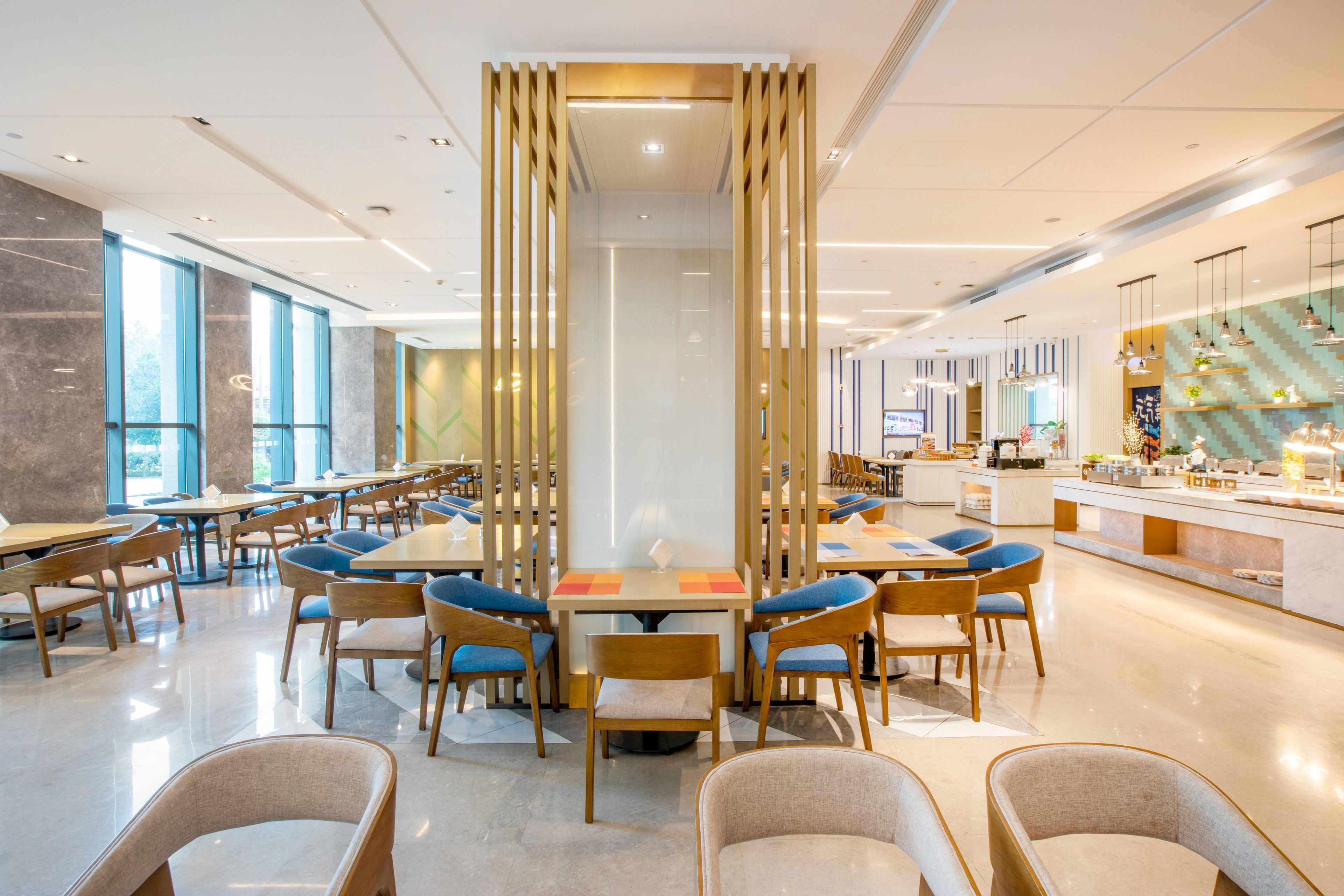 A modern dining area with high tables, chairs, and a central decorative partition.