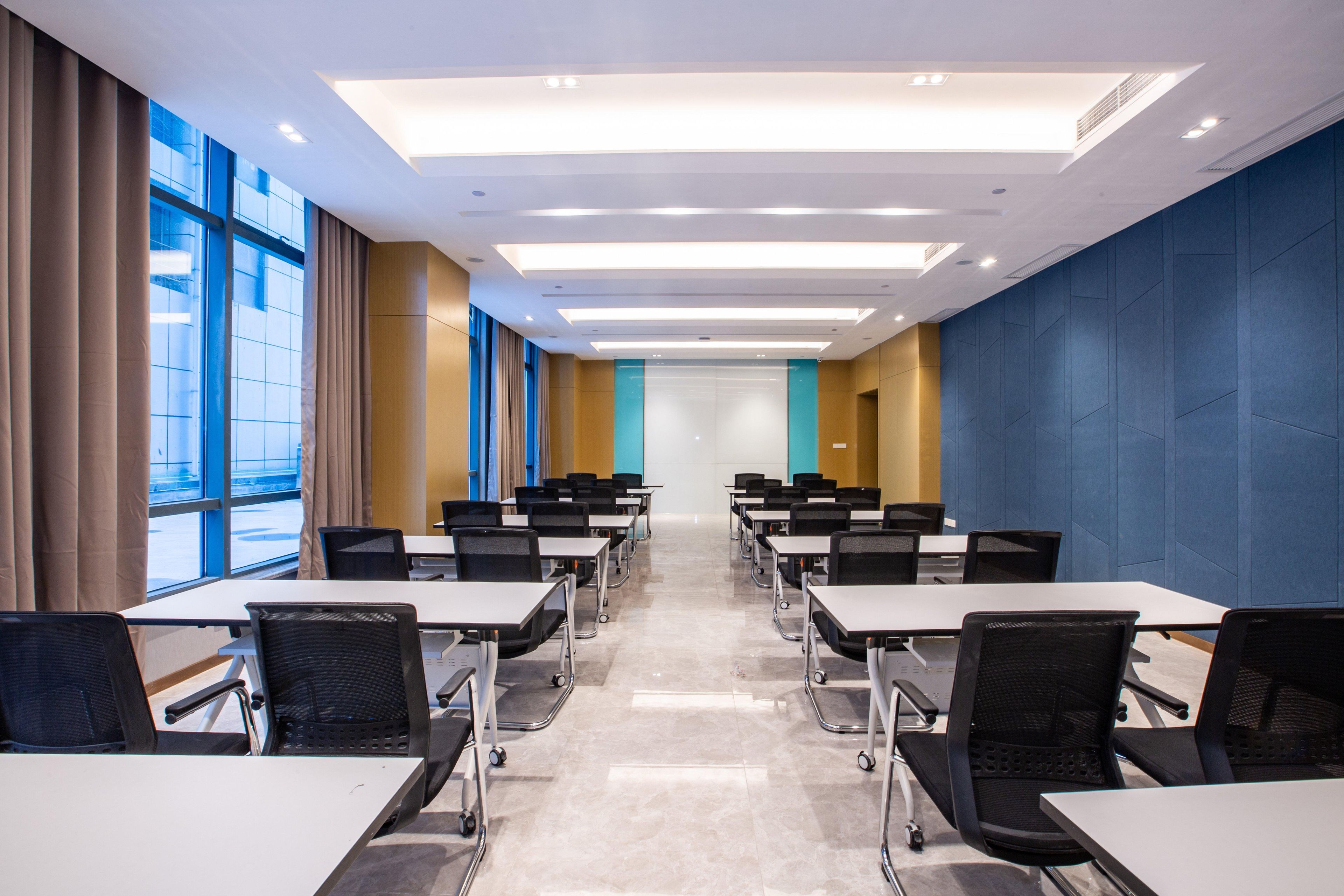 A conference room with tables, chairs, and a large window.
