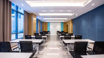 A conference room with tables, chairs, and a large window.