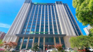 Un edificio de hotel alto con un diseño moderno, que presenta un llamativo letrero de 'Holiday Inn Express' en la parte superior.