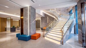 A modern lobby with a curved staircase, seating areas, and a reception desk. - Holiday Inn Express Changzhou Xinbei (Changzhou)