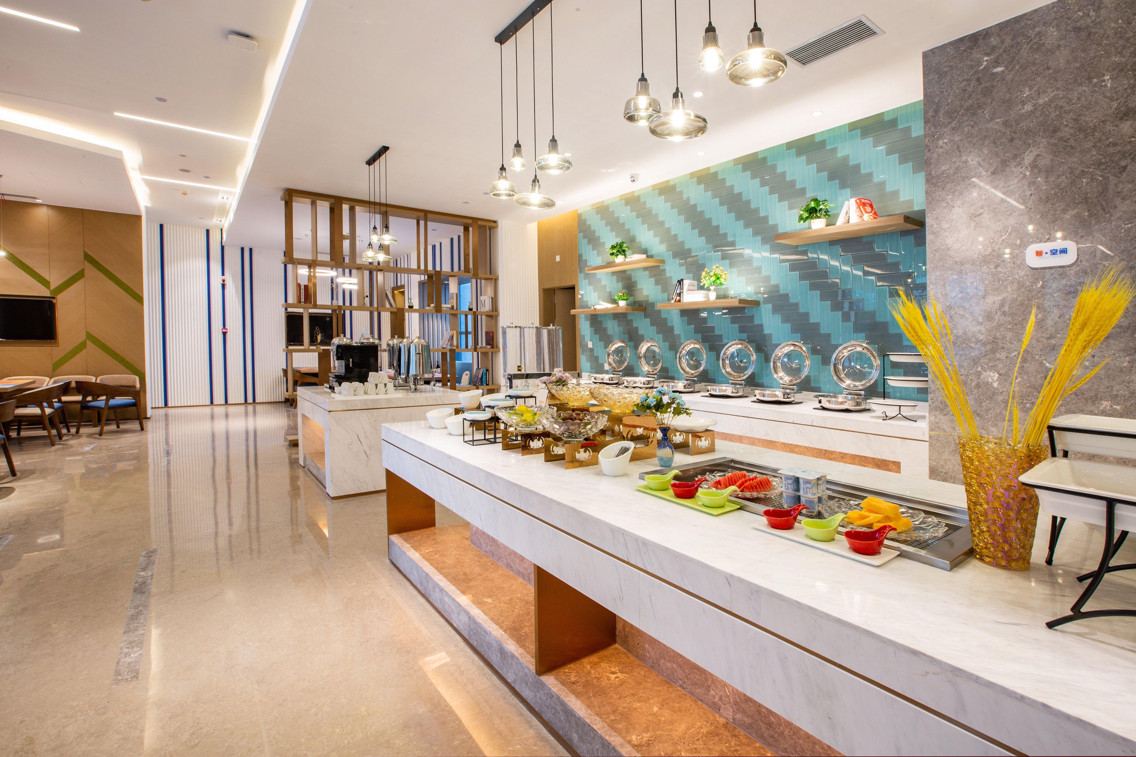 A modern hotel lobby with a marble reception desk, seating area, and a decorative wall with shelves.