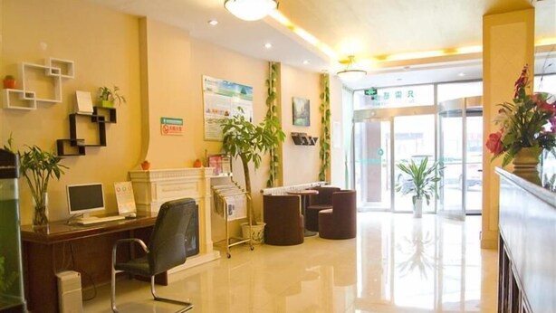 A reception area with a desk, computer, chairs, and plants. - Greentree Inn Liaocheng Gaotang Tianqi Temple Business Center Express Hotel (Liaocheng)